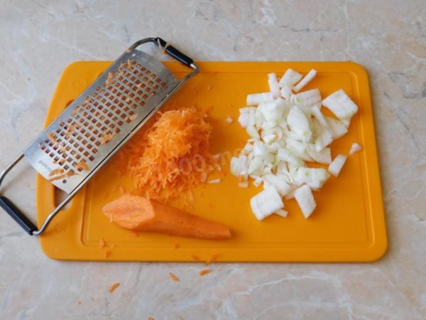 While the ground meat is browning, peel and prepare the onions and carrots. Rinse them under running water and proceed to chop them - finely dice the onions with a sharp knife and grate the carrots using a coarse or medium grater.

