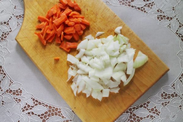 Wash and peel the onions and carrots. Dice the onions and finely chop the carrots into small cubes. To avoid onion-induced tears, rinse both the onion and the knife with cold water before cutting.

