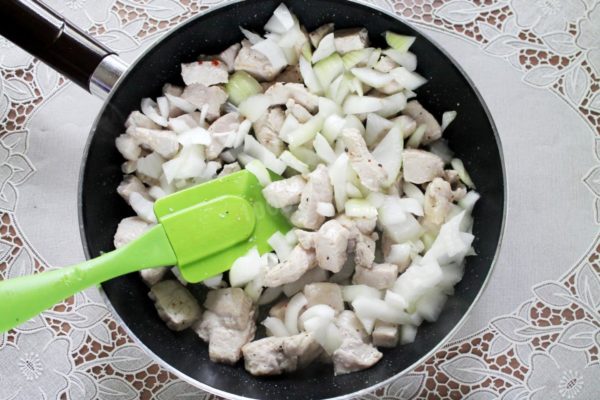 Add the diced onions and spices to the pan (but hold off on the salt for now). Stir rapidly and allow the onions to sweat a bit along with the meat.

