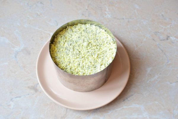 Finish the salad by adding grated egg yolks on top.

