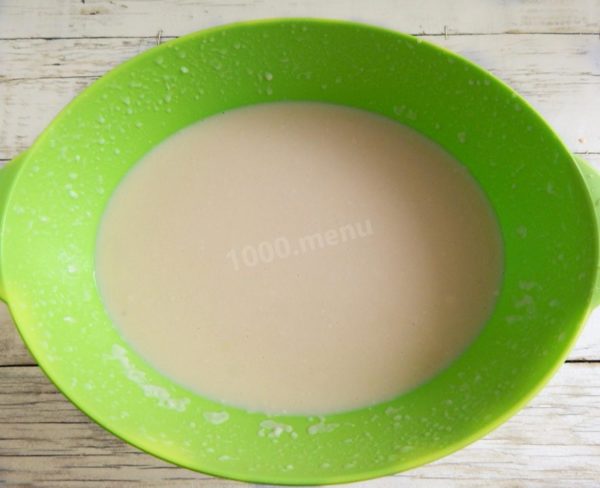 To disperse any remaining flour lumps and achieve a consistent dough, allow it to rest on the table for 15 minutes. Then, use a mixer to beat the dough once more. Incorporate vegetable oil into the dough and mix well. The dough should be thin, ensuring your pancakes turn out thin and with holes. Now you're ready to start frying.


