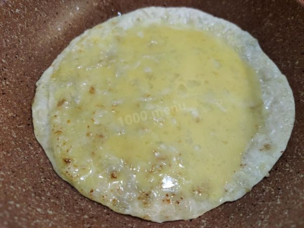 Brush the pita bread with a portion of the beaten egg mixture using a pastry brush or a tablespoon if you prefer not to dirty the brush.

