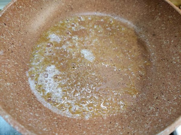 Place a frying pan on the stove and heat it. Add a teaspoon of butter to the pan and let it melt.

