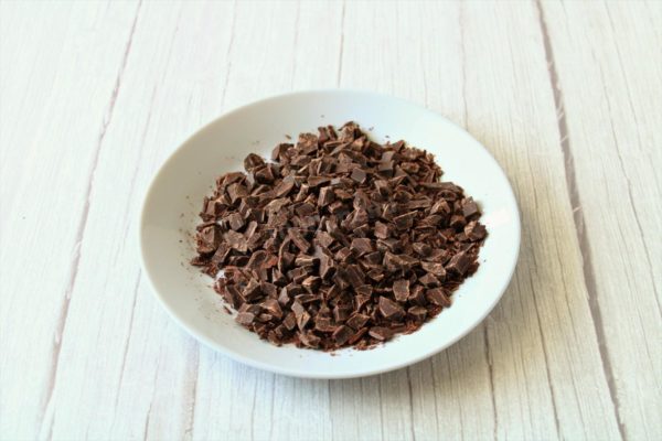 Finely chop the chocolate into small chunks using a sharp knife. For easier chopping, you can place the chocolate in the freezer for 15 minutes beforehand. When solid, it crumbles more efficiently. Adjust the size of the chocolate chunks to your liking, whether you prefer them smaller or larger.

