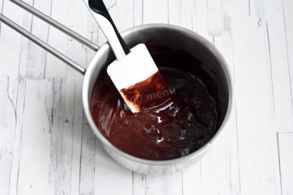 In a saucepan, combine the chocolate broken into pieces with butter. Place it on low heat and melt it with constant stirring. Alternatively, you can melt the mixture in the microwave. Allow the mixture to cool to room temperature.

