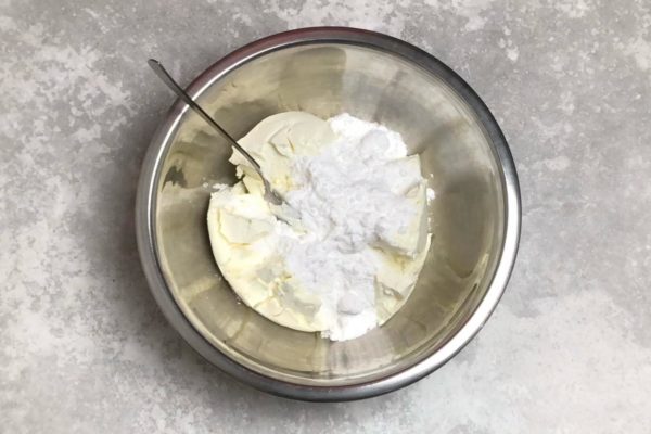 Mix the cream cheese and powdered sugar until smooth. Avoid using a mixer—simply stir the mixture to combine. Beating the mixture will introduce air bubbles, resulting in a cheesecake with an uneven texture.

