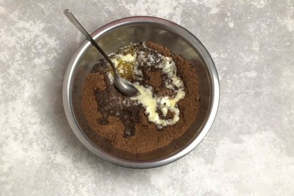 Transfer the cookie crumbs to a large bowl. Pour in the melted butter.

