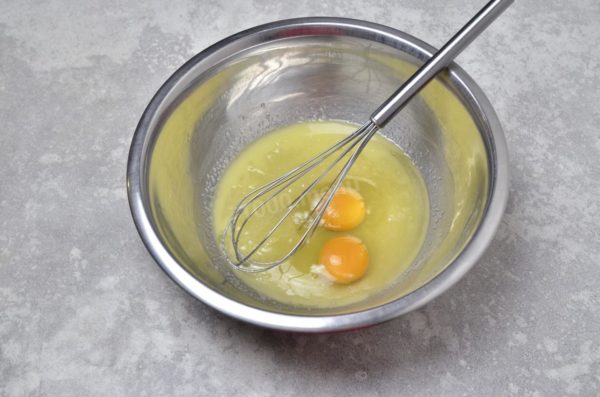 Crack the eggs into the butter-sugar mixture. Ensure to wash the eggs before use to eliminate any potential harmful bacteria present on the shell. Stir the mixture until smooth. A hand whisk suffices for this recipe, simplifying the process.

