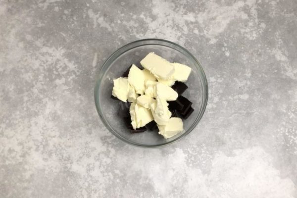 Take a bowl and break the chocolate into small pieces. Add the butter, also cut into pieces. Choose high-quality butter, without adding vegetable fats.

