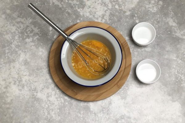 In a separate bowl, crack the eggs, add sugar and salt, then lightly beat them. Don't whip the eggs into a froth; just combine the ingredients. Rinse the eggs with warm water and baking soda to eliminate any surface bacteria.

