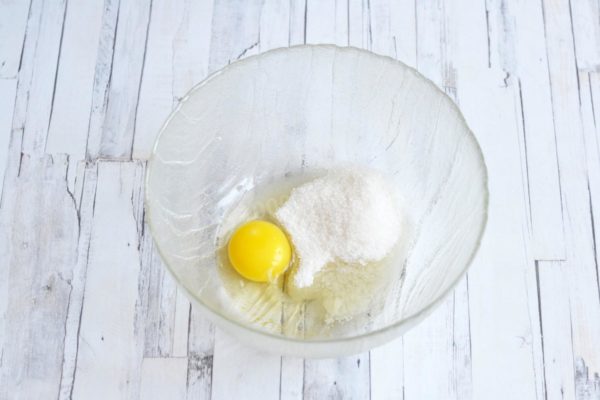 In a bowl, combine the egg, sugar, vanilla sugar, and salt. Adjust the sugar quantity to your preference. With 30g of sugar, the pancakes will have a mild sweetness. If you desire sweeter dough, add an extra tablespoon of sugar. Optionally, omit the vanilla sugar or substitute it with a small amount of vanillin (about a tip of a knife), as excessive vanillin can impart a bitter taste.

