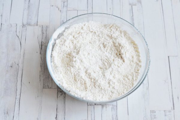 In a separate bowl, sift the flour with baking powder, then whisk the mixture to ensure even distribution of the baking powder throughout the flour.

