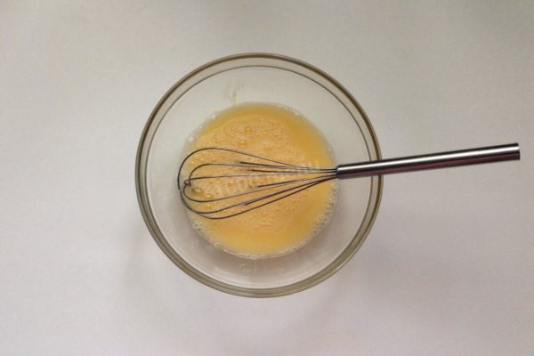 Pour water into the bowl with the egg and whisk until well combined.

