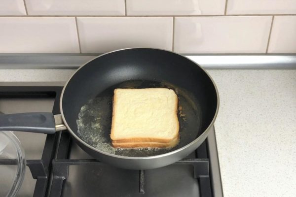 Once the cheese starts melting, place the second slice of bread on top, buttered side facing up. Gently press down on the sandwich with a spatula to help the cheese adhere to the bread.


