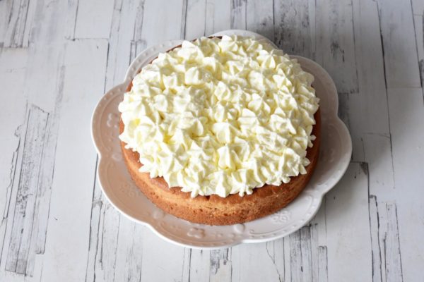 Remove the cake from its mold and place it on a serving dish. Decorate the top with the whipped cream, using a piping bag for an elegant finish.


