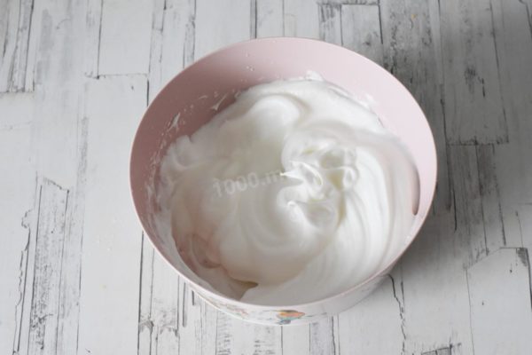 In a separate, clean bowl, beat the egg whites into a light foam. While continuing to beat, gradually add 20g of sugar and vanilla sugar until you achieve a firm mixture that remains in the bowl when inverted. Ensure the cream (if using) is high in fat content (at least 33%) and both the cream and mixing bowl are chilled from being in the refrigerator for 1-2 hours.



