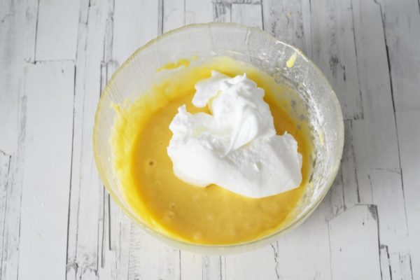 Fold the whipped egg whites gently into the batter using a spatula, with movements from top to bottom to maintain airiness.
